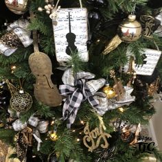 a decorated christmas tree with musical instruments and ornaments on it's branches in gold, black and white colors