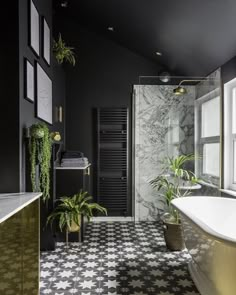 a black and white tiled bathroom with gold accents, potted plants on the counter