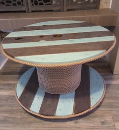 a round table made out of wood and rope on top of a hard wood floor