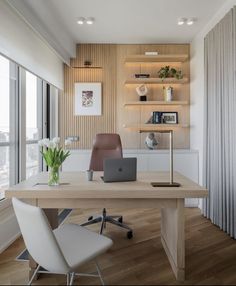 a desk with a laptop on it in front of a window