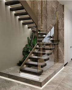 an elegant staircase with glass railing and marble steps leading up to the second floor in this modern home