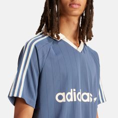 a man with dreads wearing a blue adidas shirt