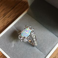 an opal and diamond ring in a box