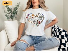 a woman sitting on a couch wearing a white t - shirt with the words scotland printed on it