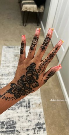 a woman's hand with henna tattoos on it