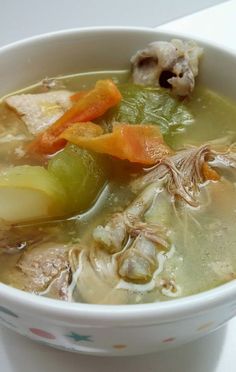 a white bowl filled with soup and vegetables