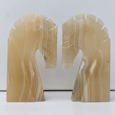 two sculptures made out of marble on a white surface