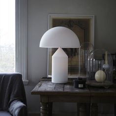 a living room with a couch, table lamp and pictures on the wall in black and white