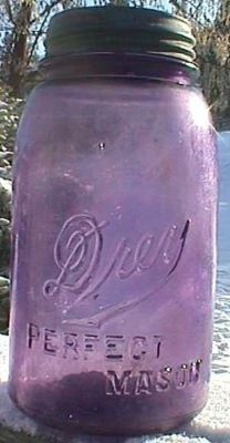 a purple mason jar sitting in the snow