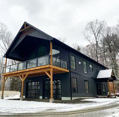 a large black house sitting in the snow