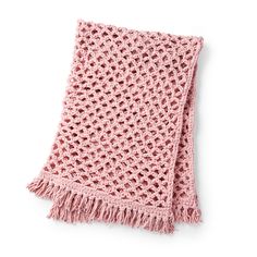 a pink crocheted blanket with fringes