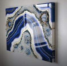 a blue and white painting hanging on the wall