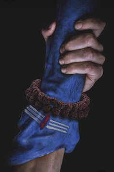 a man holding onto a blue object with his hand on it's leg and the other arm wrapped around him