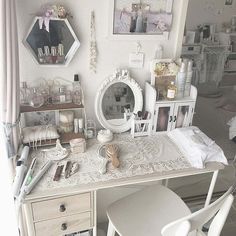 a white desk topped with lots of drawers next to a wall covered in pictures and other items