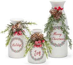 three white vases with christmas decorations on them