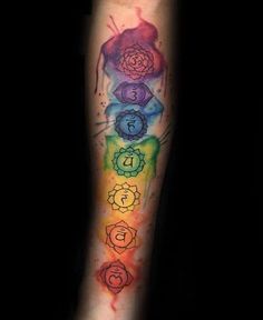 a colorful tattoo with seven chakras on the arm and one in the center