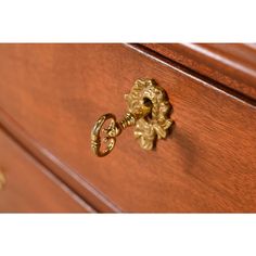 an ornate brass handle on a wooden dresser