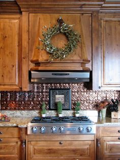 a kitchen with wooden cabinets and a wreath on the wall above the stove top oven