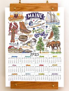 a calendar hanging on a wall next to a wooden plaque with the names and symbols of maine