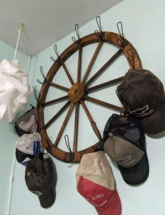 several hats are hanging on the wall near a wheel