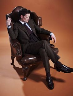 a man in a suit and tie sitting on a chair