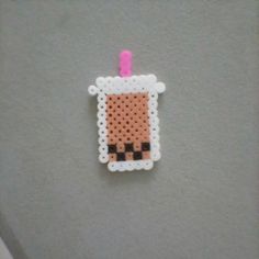 a piece of perler bead is hanging on the wall next to a toothbrush