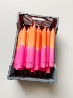 several pink and orange toothbrushes in a holder