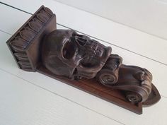 a carved wooden shelf with an elephant head on it