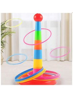 a stack of colorful plastic rings on top of a white floor next to a window