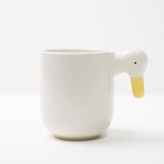 a white coffee cup with a yellow ducky sticking out of it's side