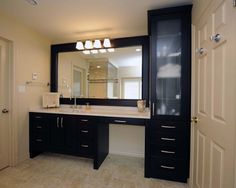 a bathroom with a large mirror, sink and two doors leading to another room in the house