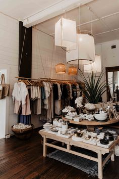 a room filled with lots of clothes and plates on top of a wooden table in front of a mirror