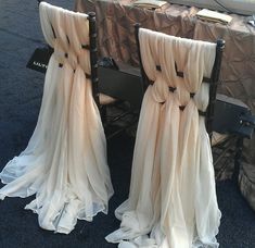 two chairs covered in white cloths sitting next to each other