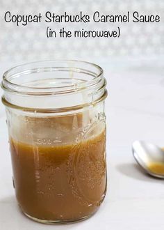 a jar filled with caramel sauce next to a spoon