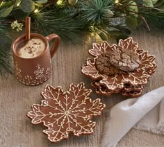 three cookies and two mugs on a table