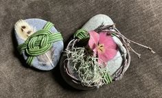 two rocks with plants and flowers on them