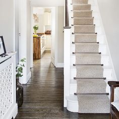 a staircase leading up to a kitchen and dining room in a house with hardwood floors