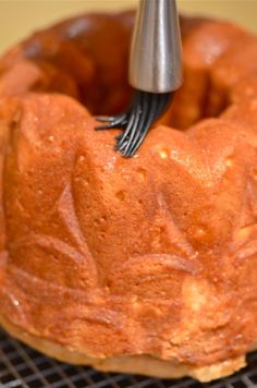 a bundt cake with a fork sticking out of it's middle on a cooling rack