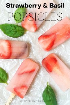 four popsicles with strawberries and basil on them