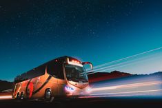 a bus is driving down the road at night with motion blurs in the foreground