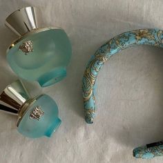 two blue glass vases sitting next to each other on a white tablecloth covered surface