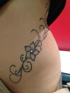 a woman's stomach with a tattoo design on the lower part of her belly