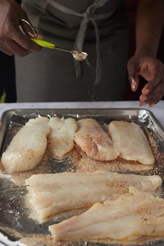 someone is cooking fish in a pan on the table