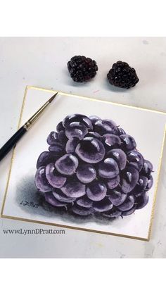 some blackberries are sitting on top of a white table next to a pen and paper