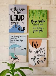 three canvases with quotes on them hang on a wall next to a potted plant