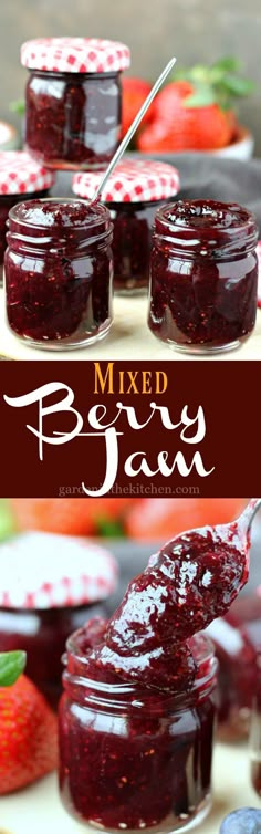 homemade mixed berry jam in jars with spoons and strawberries on the table behind it