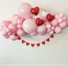 balloons and hearts are arranged on the wall