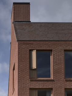 a red brick building with two windows and a clock