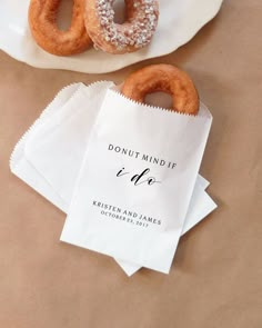 two donuts sitting on top of a white plate next to napkins and paper