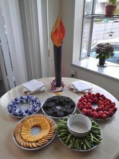 a table topped with plates filled with different types of food next to a fire pit